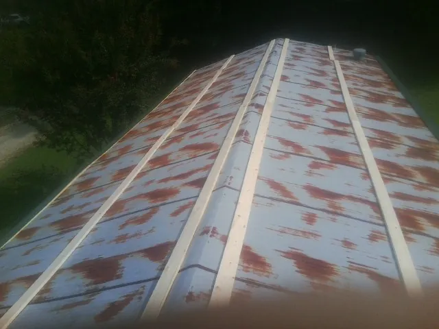 Rusted metal roof panels with new wood purlins before replacement — Storm Damage Roof Repair in Sewell by Roofing Brothers