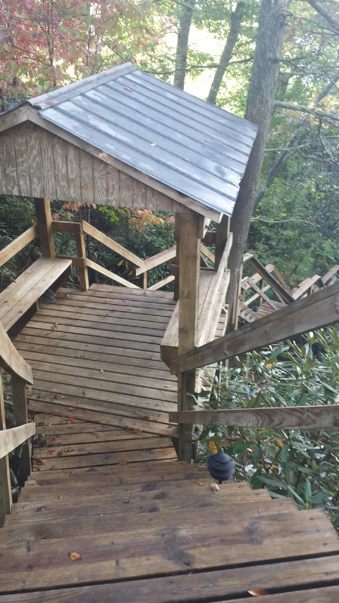 Metal roofed shelter over wooden steps on a wooded walkway — Skylight Repair & Installation work by our crew in Sewell