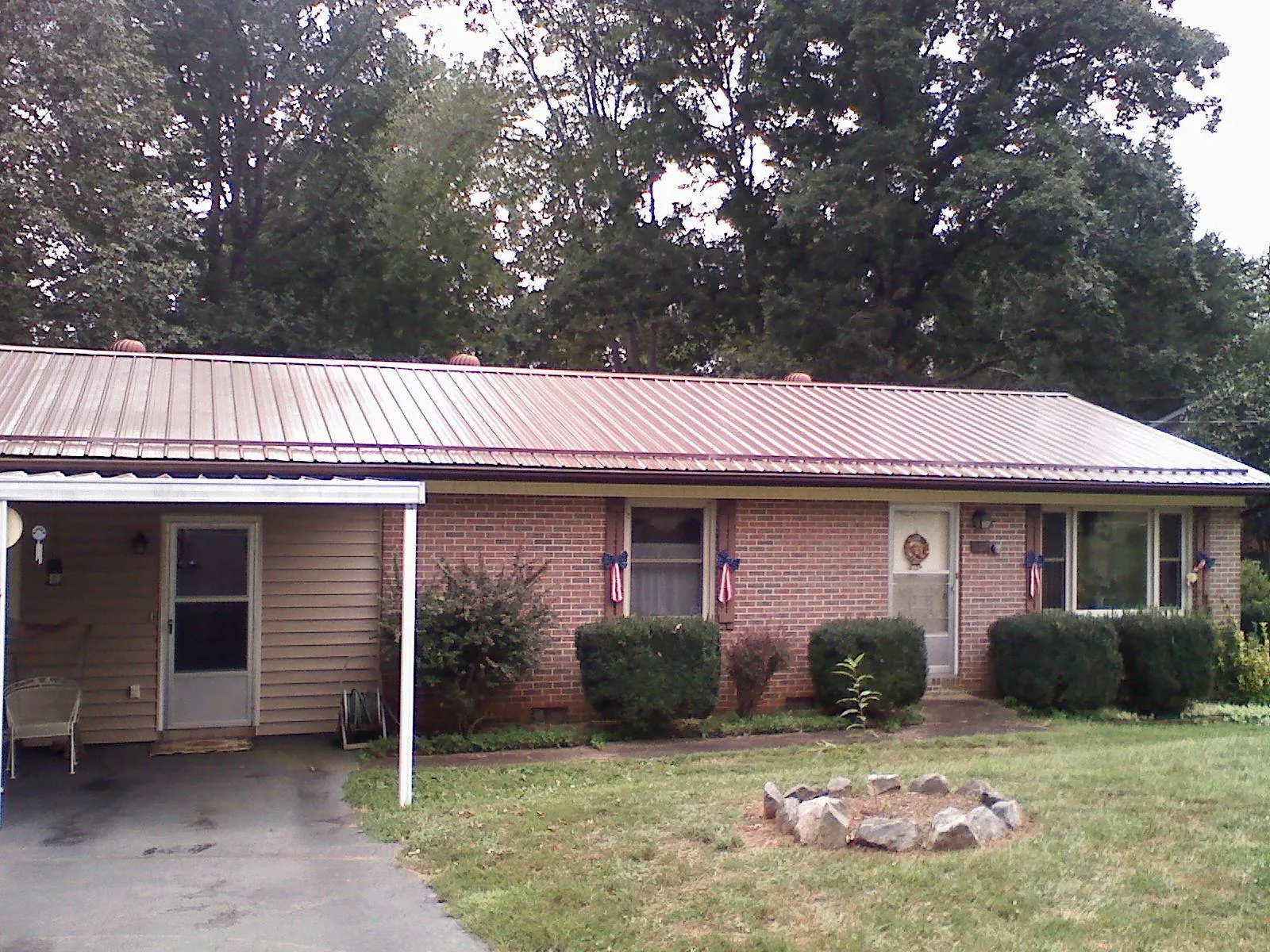 Bronze metal roof and carport on a brick ranch home — Roof Repair work by our crew in Sewell